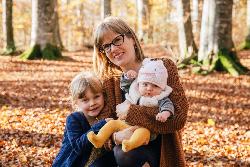 photo d'une maman avec deux enfants en foret à l'automne