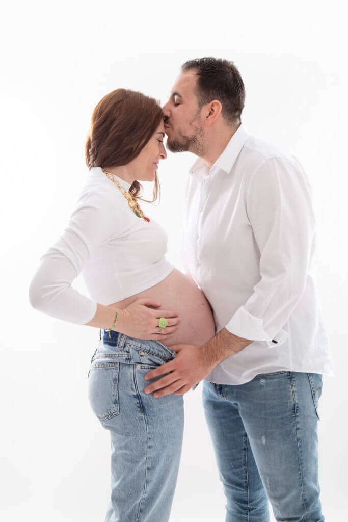 papa qui embrasse future maman pendant une séance photo